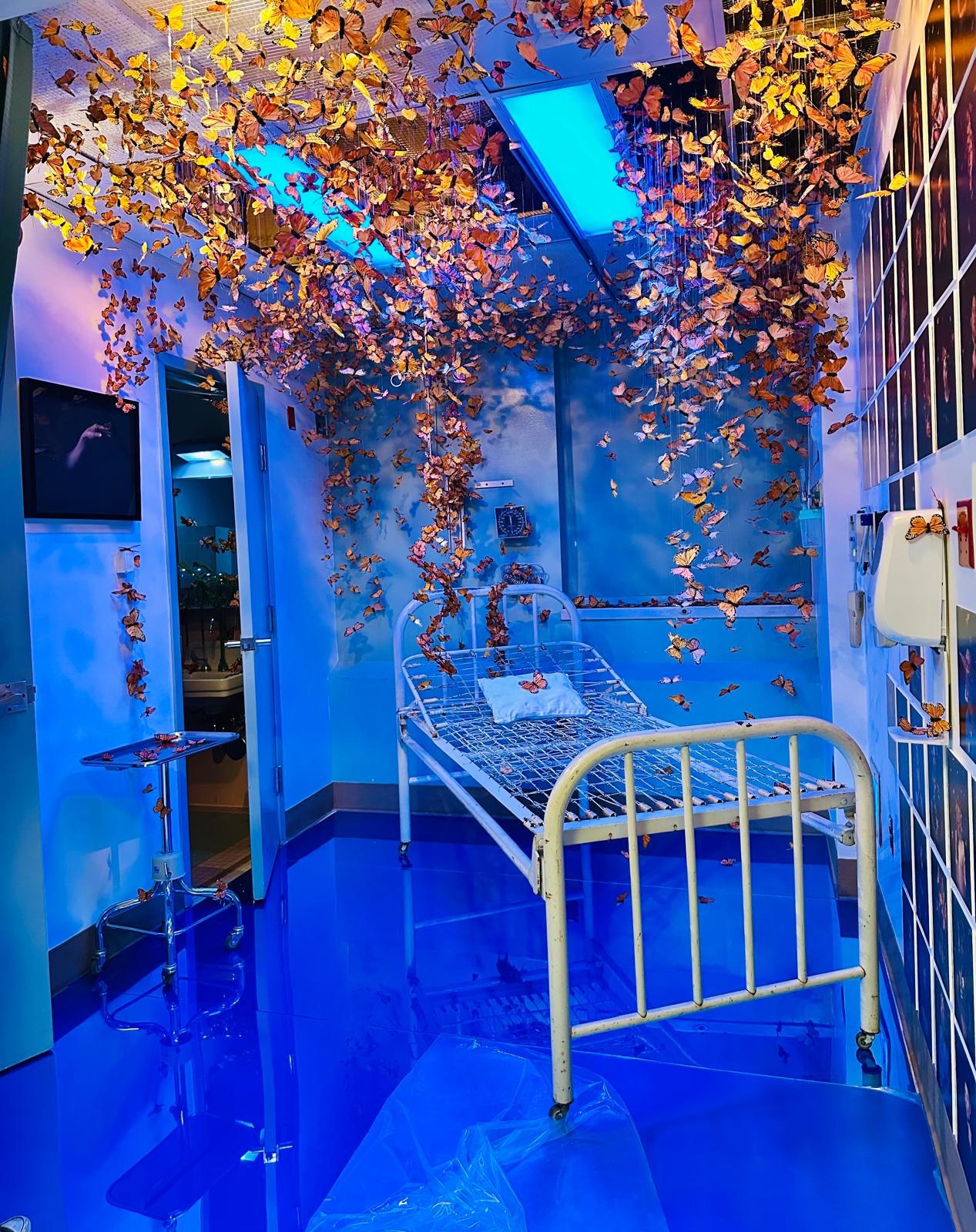 Monarch installation with suspended silk butterflies above a hospital bed